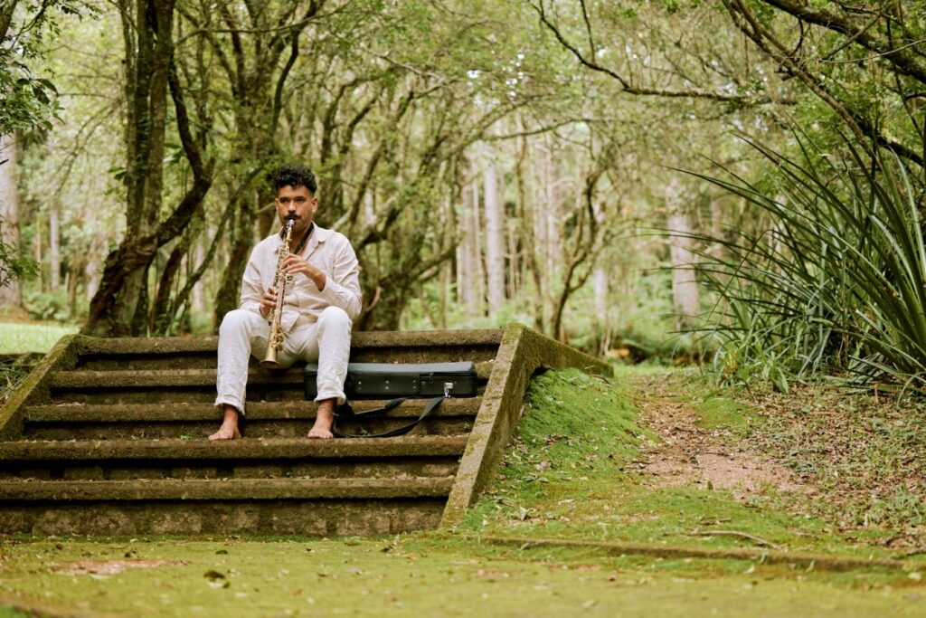 Man playing saxophone on forest steps